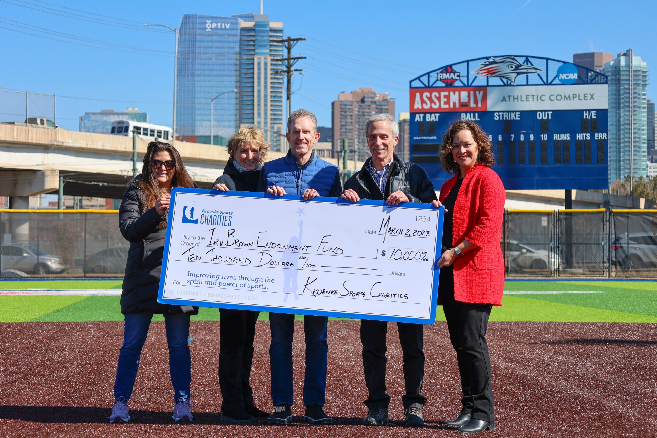 Four people from Kroenke Sports Charities present MSU Denver VP for Advancement Christine Márquez-Hudson with a check for $10,000 for the Irv Brown Endowment Fund