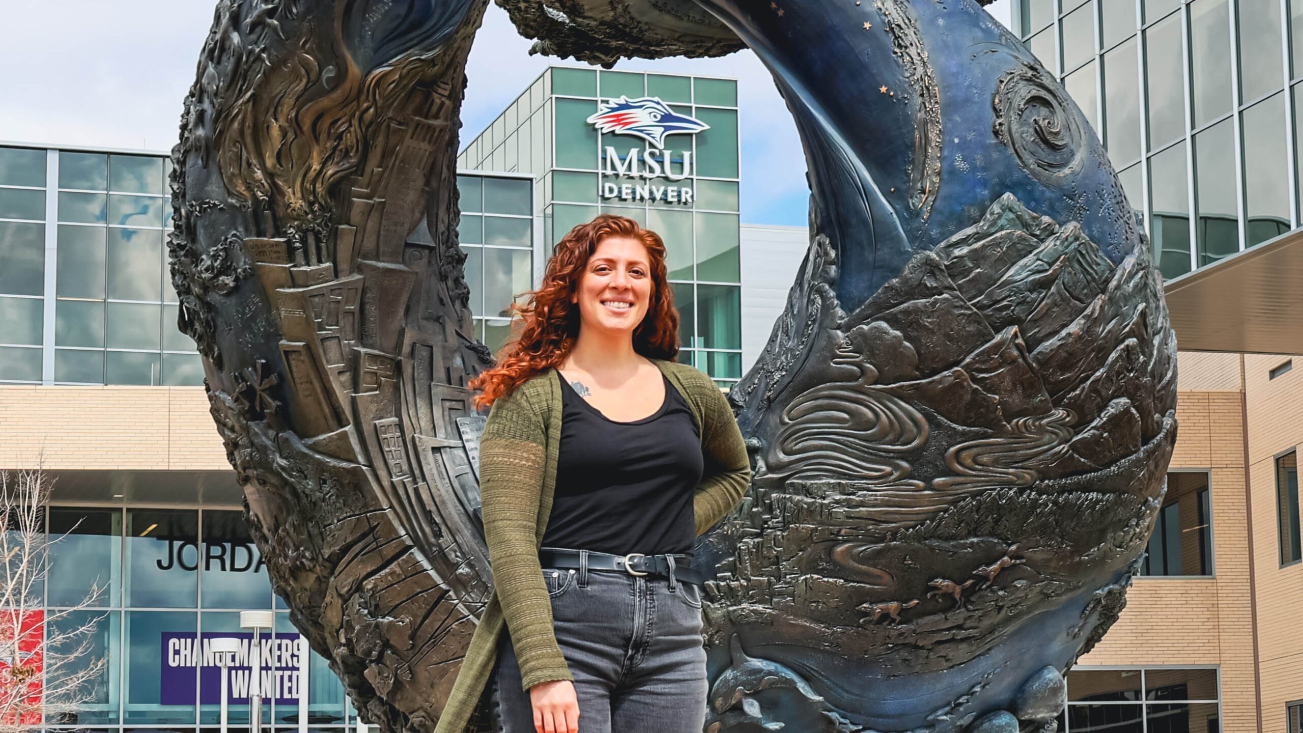 Natassa Christides standing in front of the One World One Water statue in front of the Student Success Building