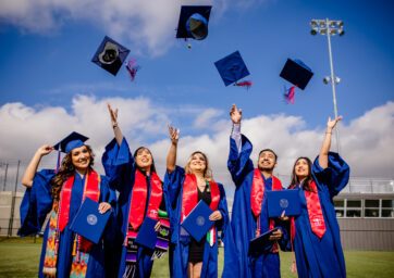 Graduates throwing mortar boards in the air.