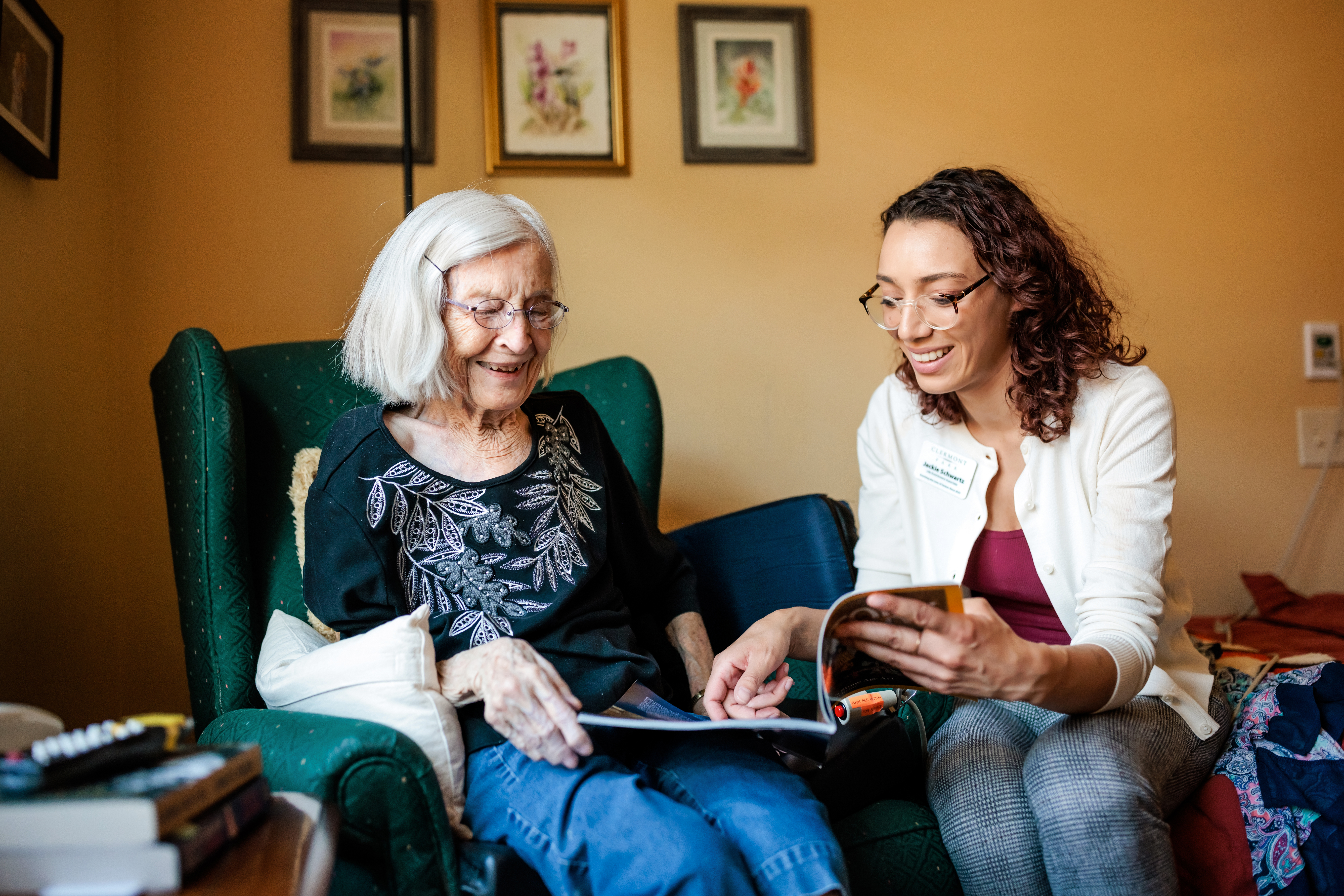 MSU Denver student Jackie Schwartz reads about Egyptology and mummification with resident Jeanne Dietrich in her room at Clermont Park- senior community living on May 17, 2023. Photo by Alyson McClaran