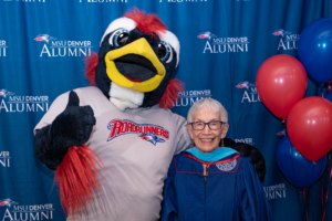Anna Jo Garcia Haynes stands with Rowdy the Roadrunner at the Master of Arts in Teaching Hooding Ceremony, May 8th, 2023.