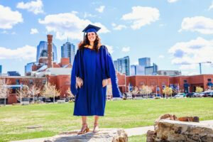 Natassa standing in front of the Tivoli with downtown Denver in the background