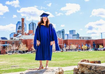 Natassa standing in front of the Tivoli with downtown Denver in the background