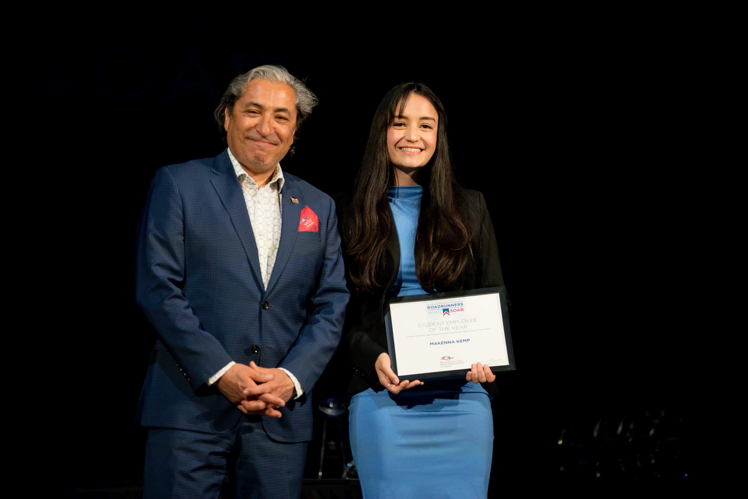 A photo of a student receiving a student employee of the year award.