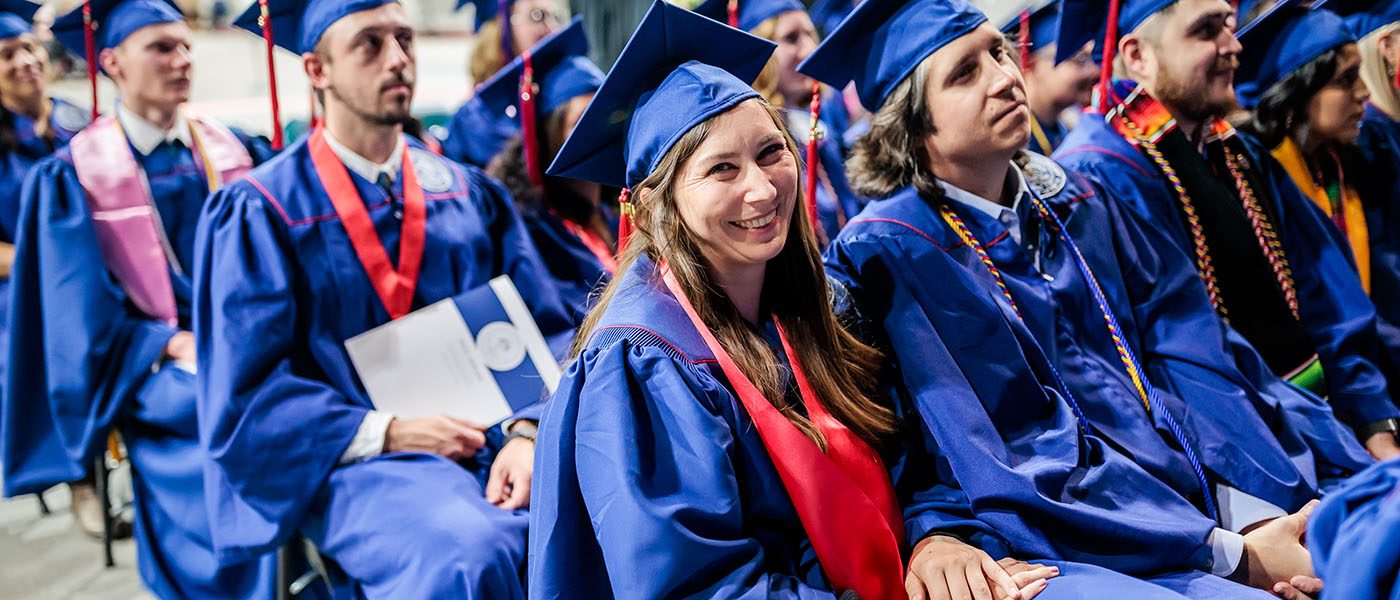 Happy graduates sit in the audience prepared to receive their diplomas at MSU Denver Spring 2023 commencement ceremony.