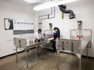 Wide shot of students developing photographs.