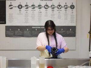 A student developing photographs.