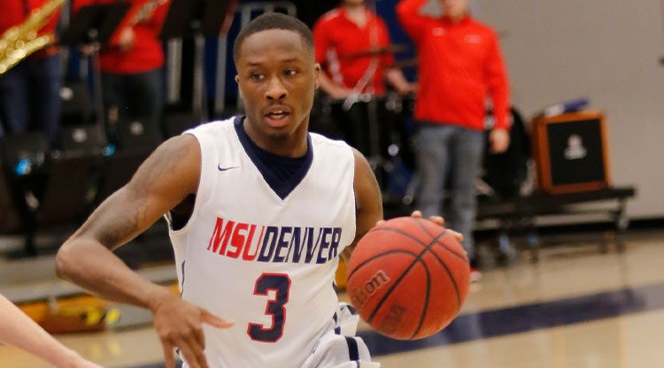 MSU Denver basketball player dribbles towards the hoop
