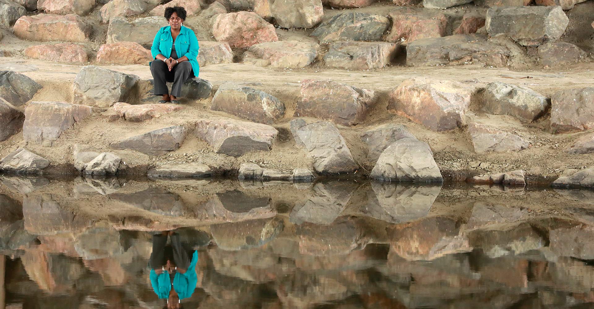 Woman overlooking river with her reflection showing