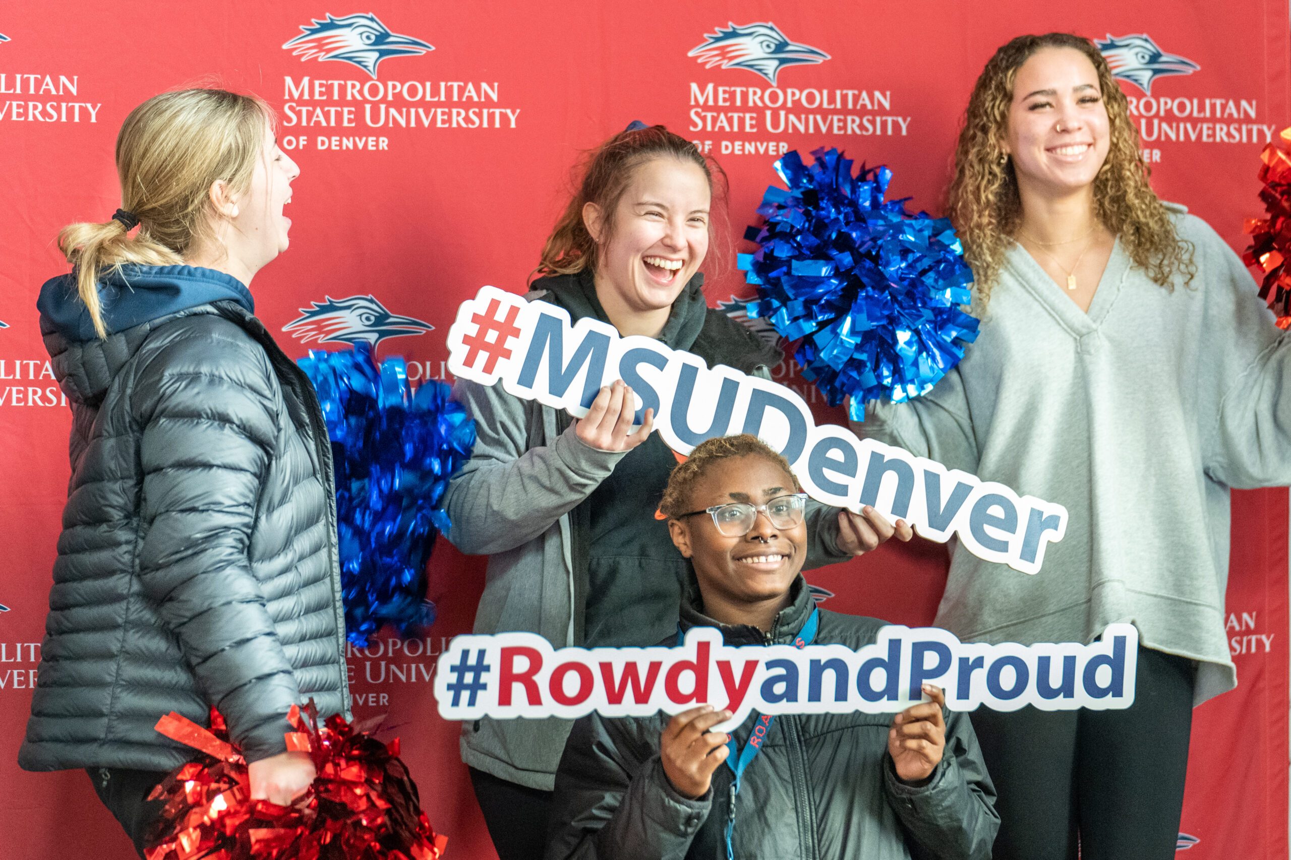 Students gathered and posing in front of an MSU Backdrop with hashtag signs