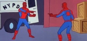 Two people dressed as Spider-Man pointing at each other.
