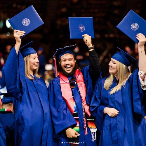 Instagram graphic of three graduates holding up their diplomas and smiling at commencement