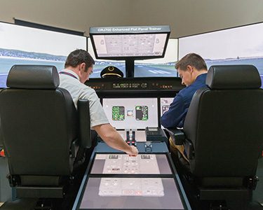 Two MSU Denver students operating a flight simulator on Auraria Campus.