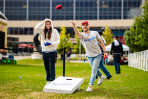 Students playing cornhole on a lawn at MSU Denver.