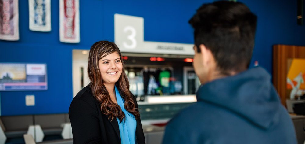A woman in business attire shaking the hand of another person in JSSB