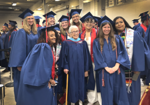 Photograph of Anna Jo Garcia Haynes posing in regalia with Early Childhood Education graduates backstage at the Spring 2023 commencement ceremony.