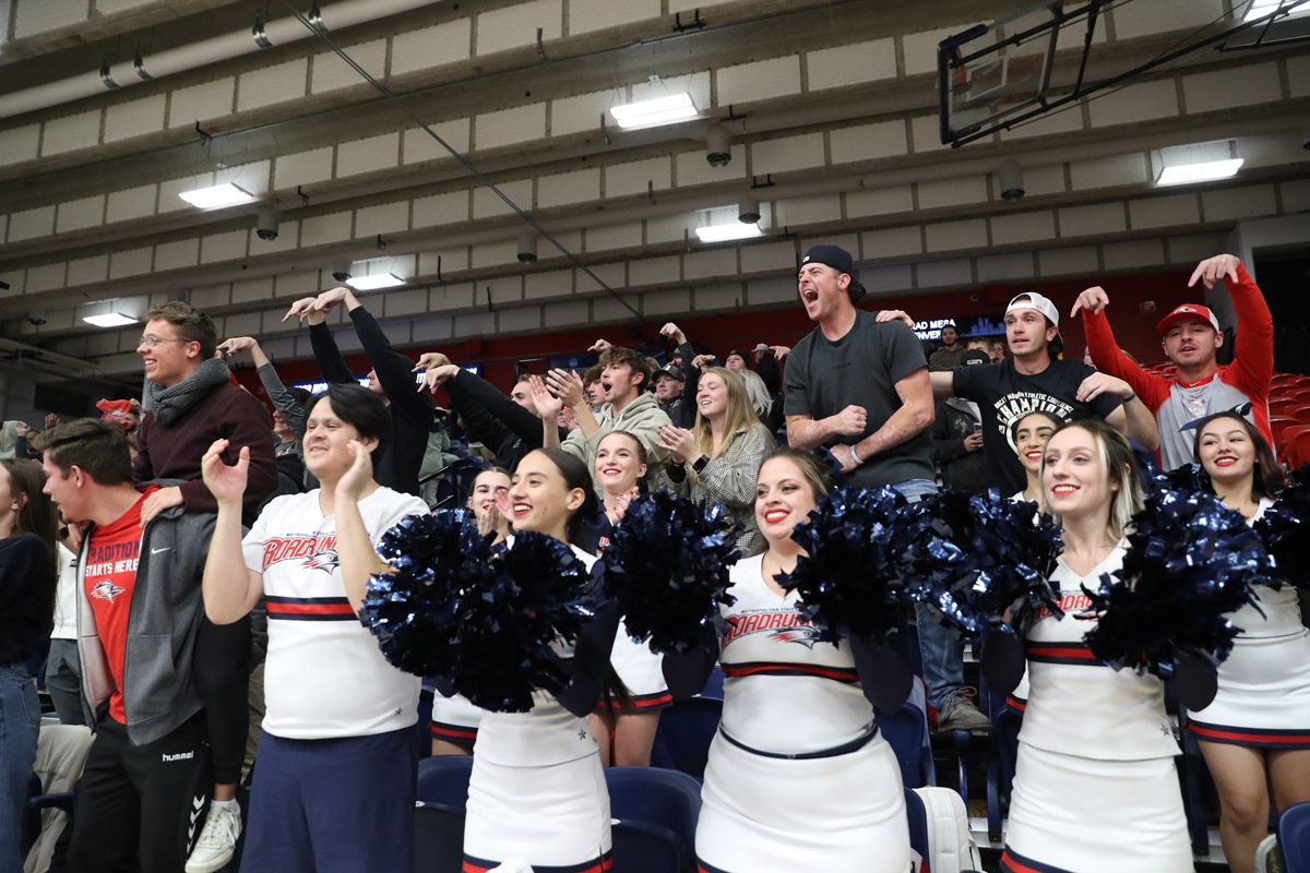 Fans and cheerleaders cheering at a Roadrunners volleyball match