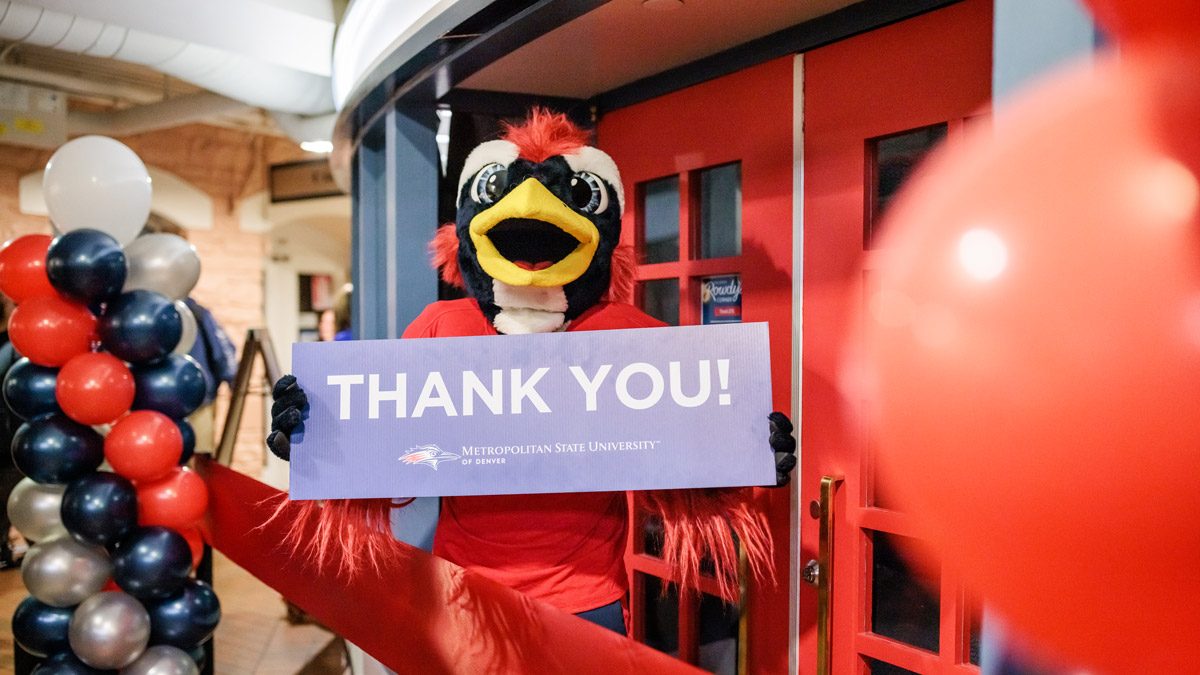 Rowdy holding a Thank You sign in front of Rowdy's Corner at the grand opening in November 2022.