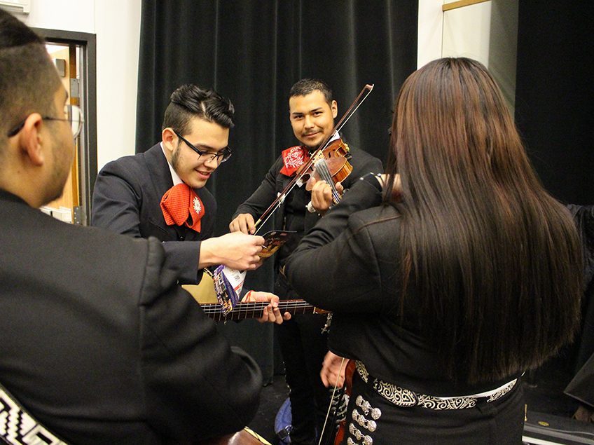 mariachi perfomers backstage practicing instruments