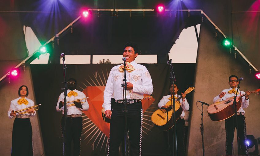 mariachi singer smiling in front of mariachi group