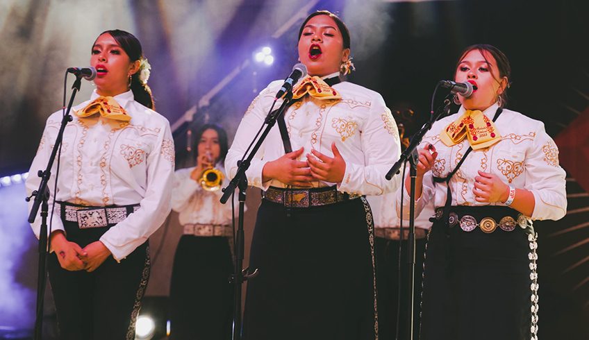 three female mariachi singers performing