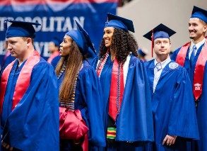 MSU Denver graduates smiling and in their regalia standing in line at the spring 2023 commencement ceremony