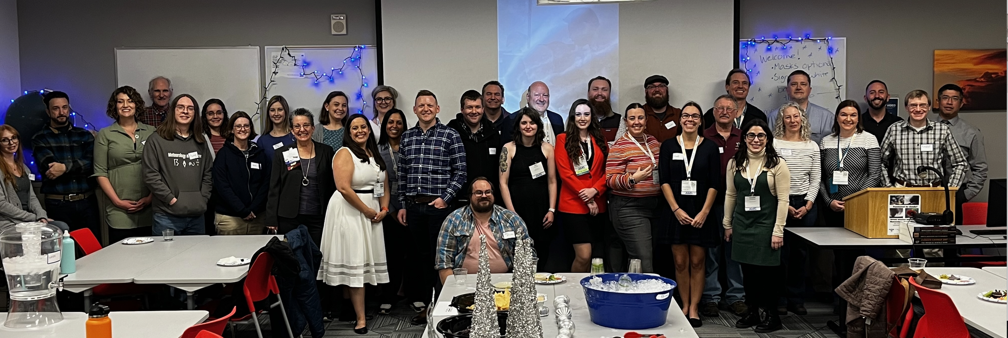 Photo of about 35 people posing at a meteorology alumni party in the meteorology classroom