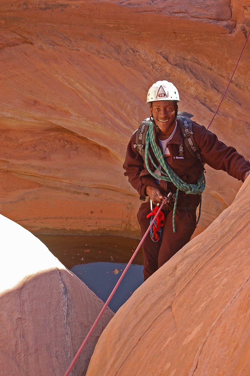 Man rappelling into canyon