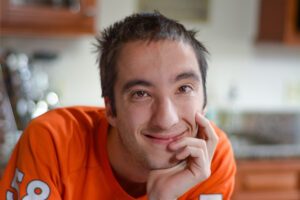 Portrait photograph of a student smiling and wearing a Denver Broncos jersey.