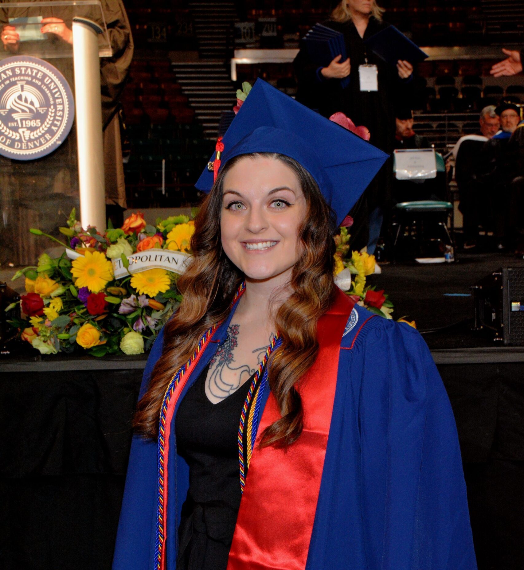 accounting undergraduate student (Deja) in graduation regalia at commencement in front of stage