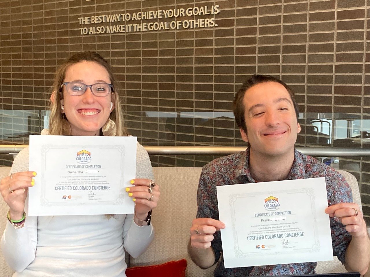 Decorative: Two Inclusive Higher Education Students hold up certificates for becoming a Certified Colorado Concierge
