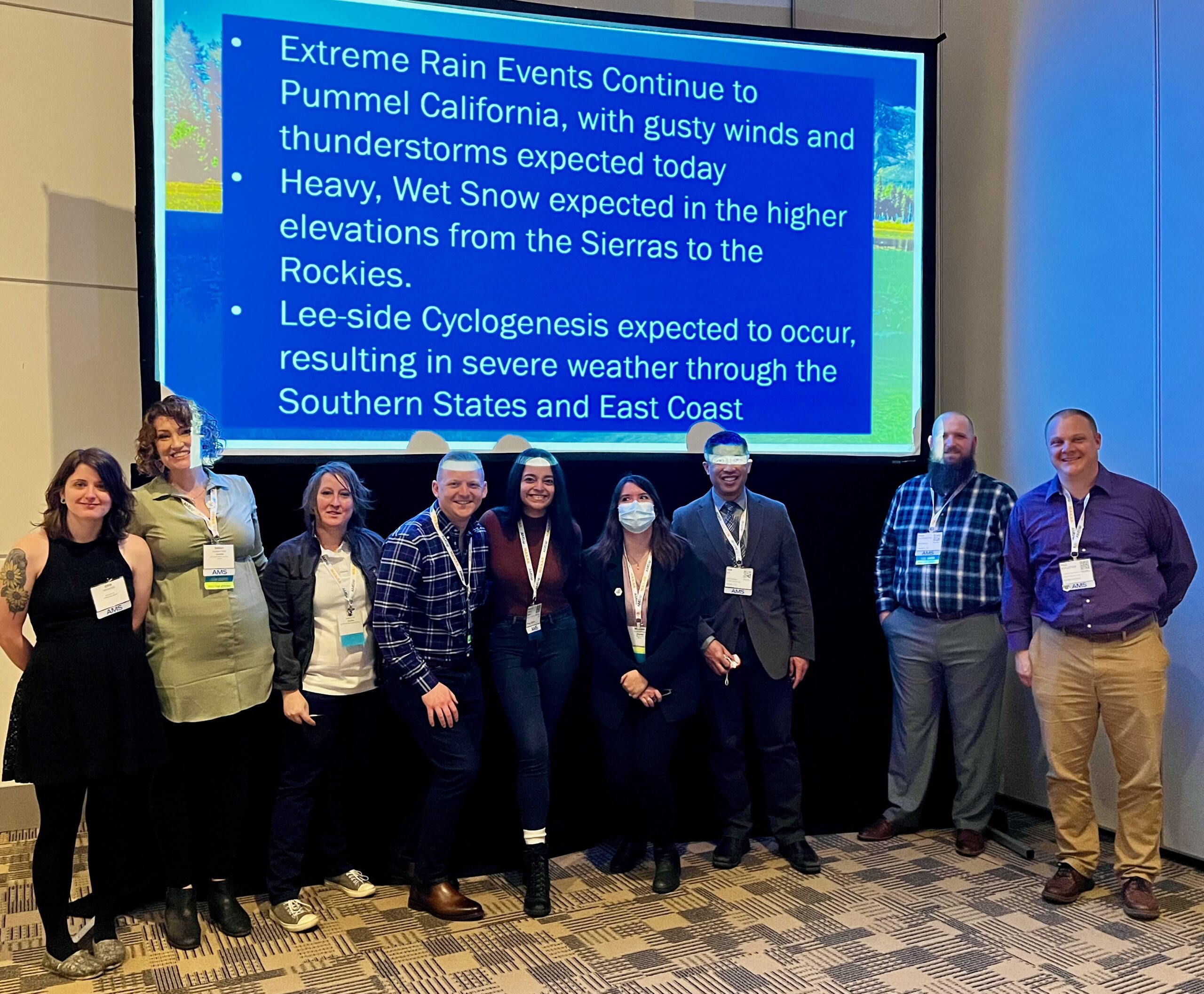 Students posing in front of a slide at the AMS conference after leading weather discussion