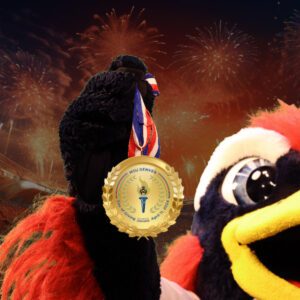 Social media profile image for Day of Giving with Rowdy holding a gold medal with fireworks in the background