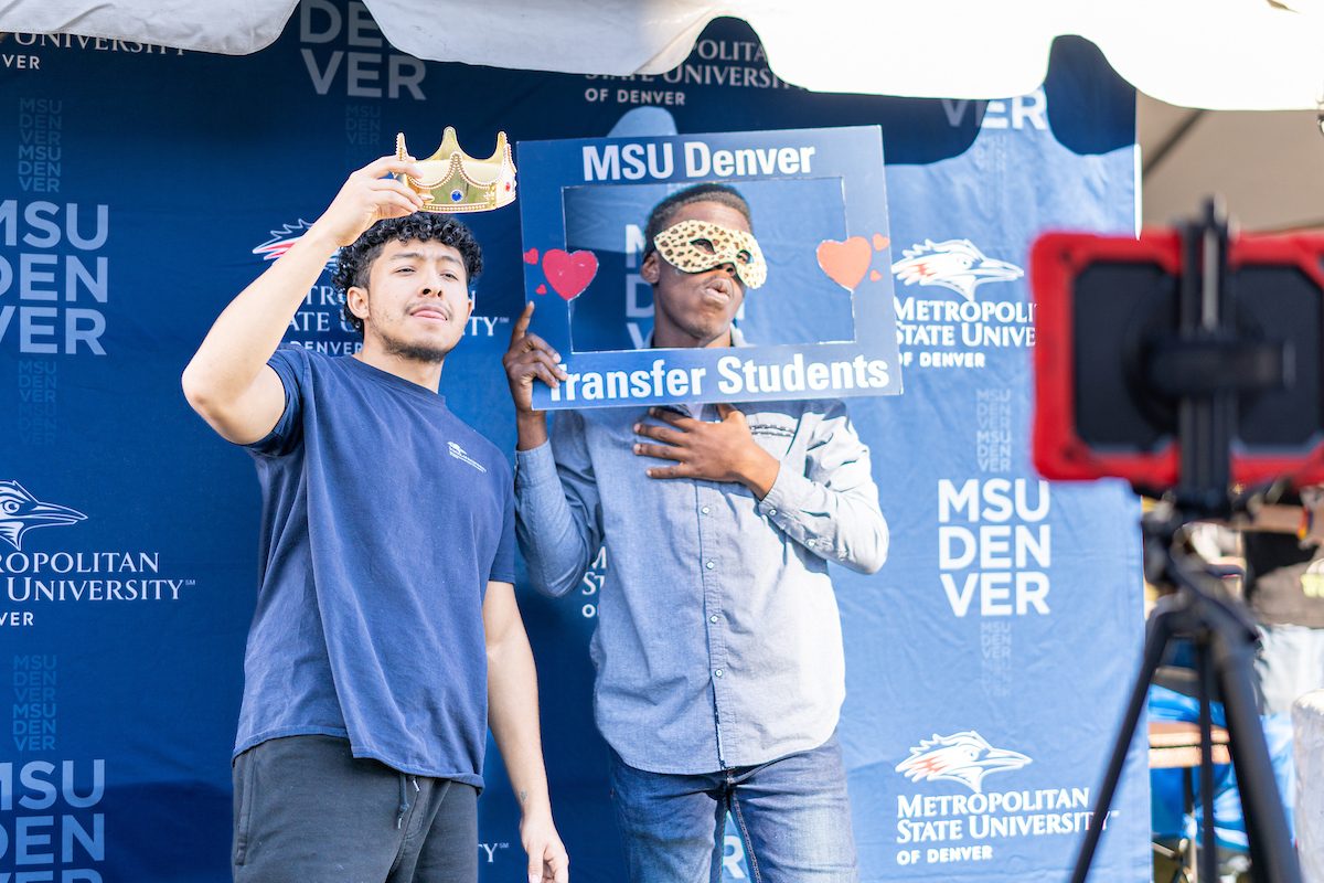 Two students making funny faces in a photo booth during the Kickoff Carnival