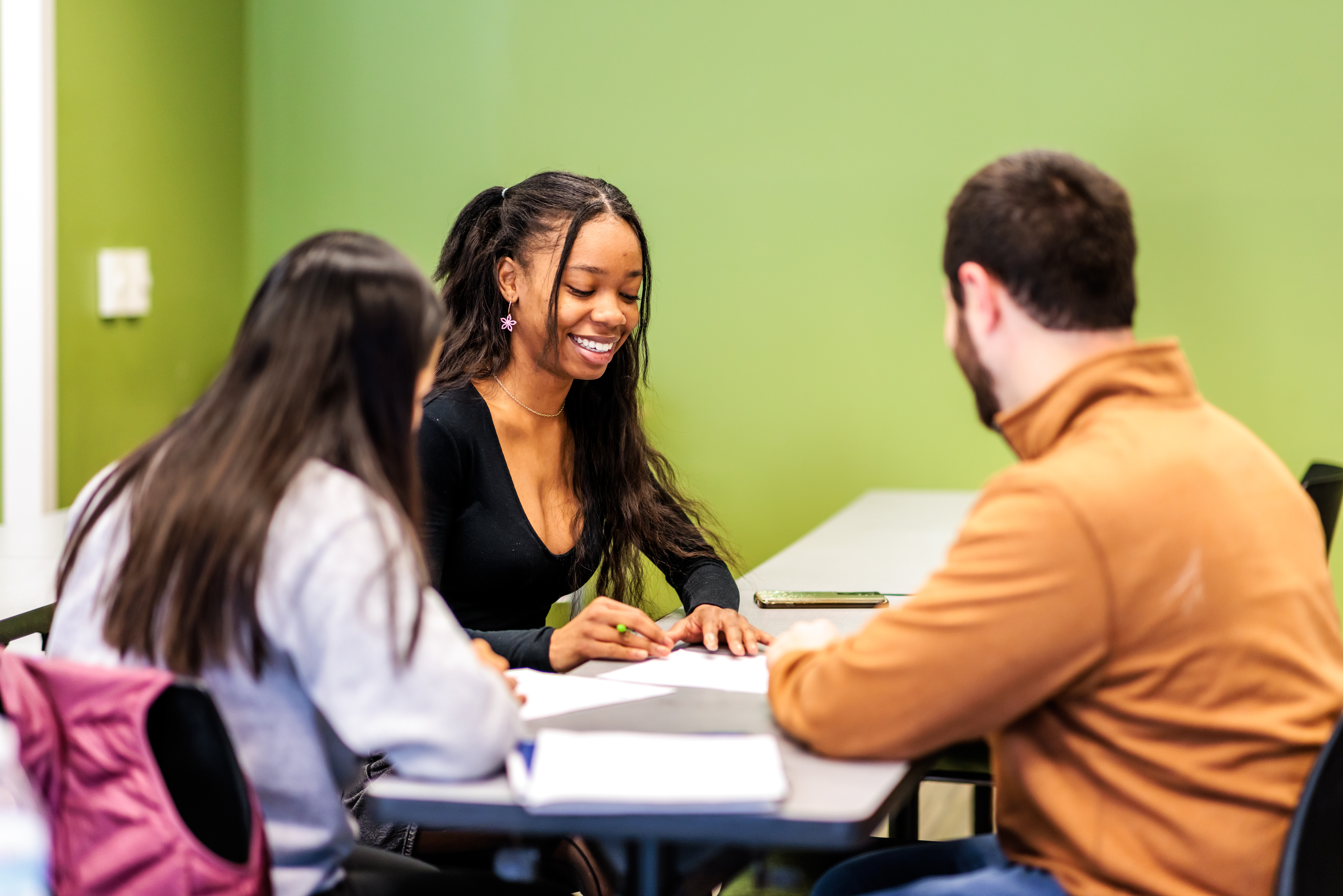 3 students engaged in a group discussion in a classroom at MSU Denver