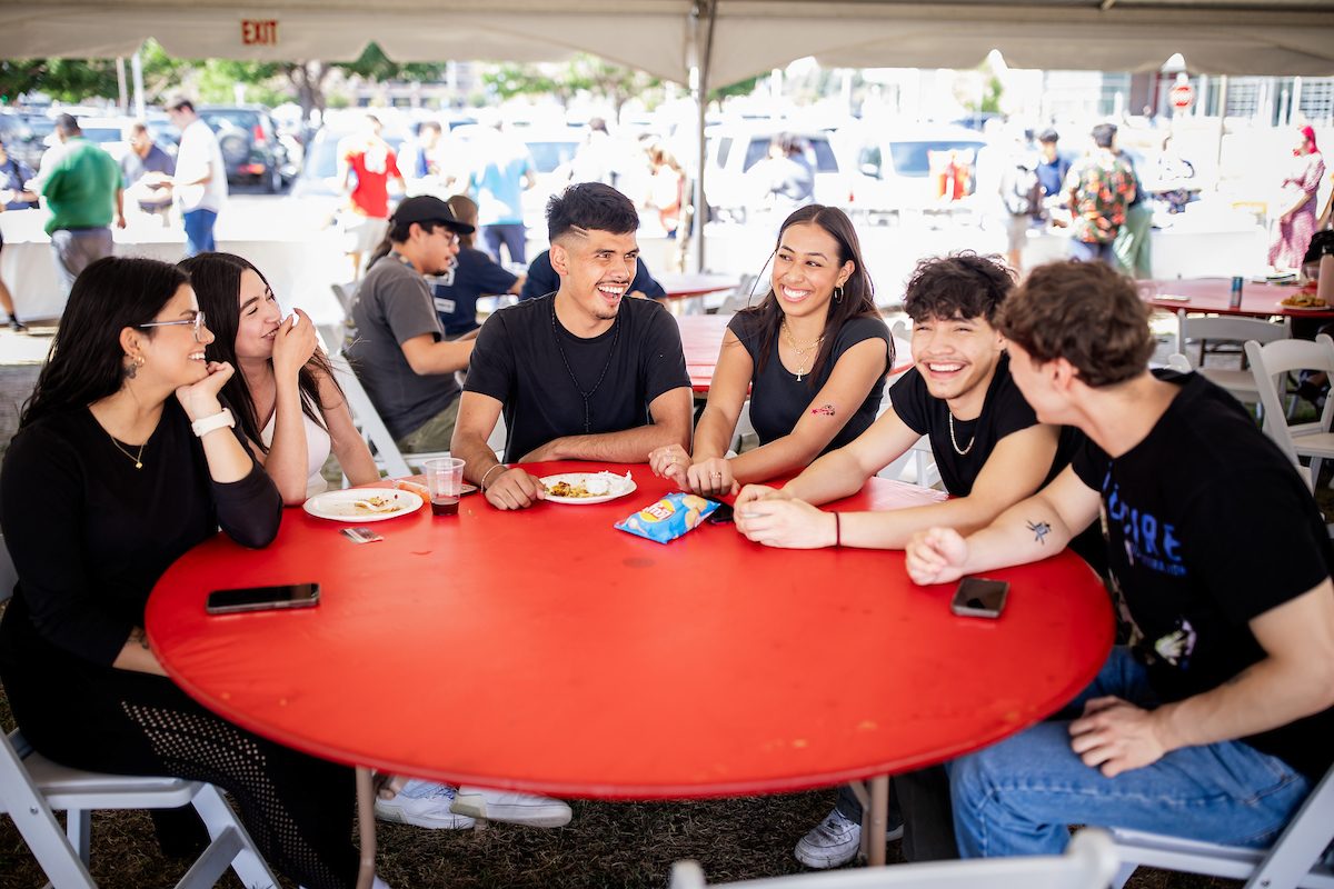 Students sitting around a table and laughing