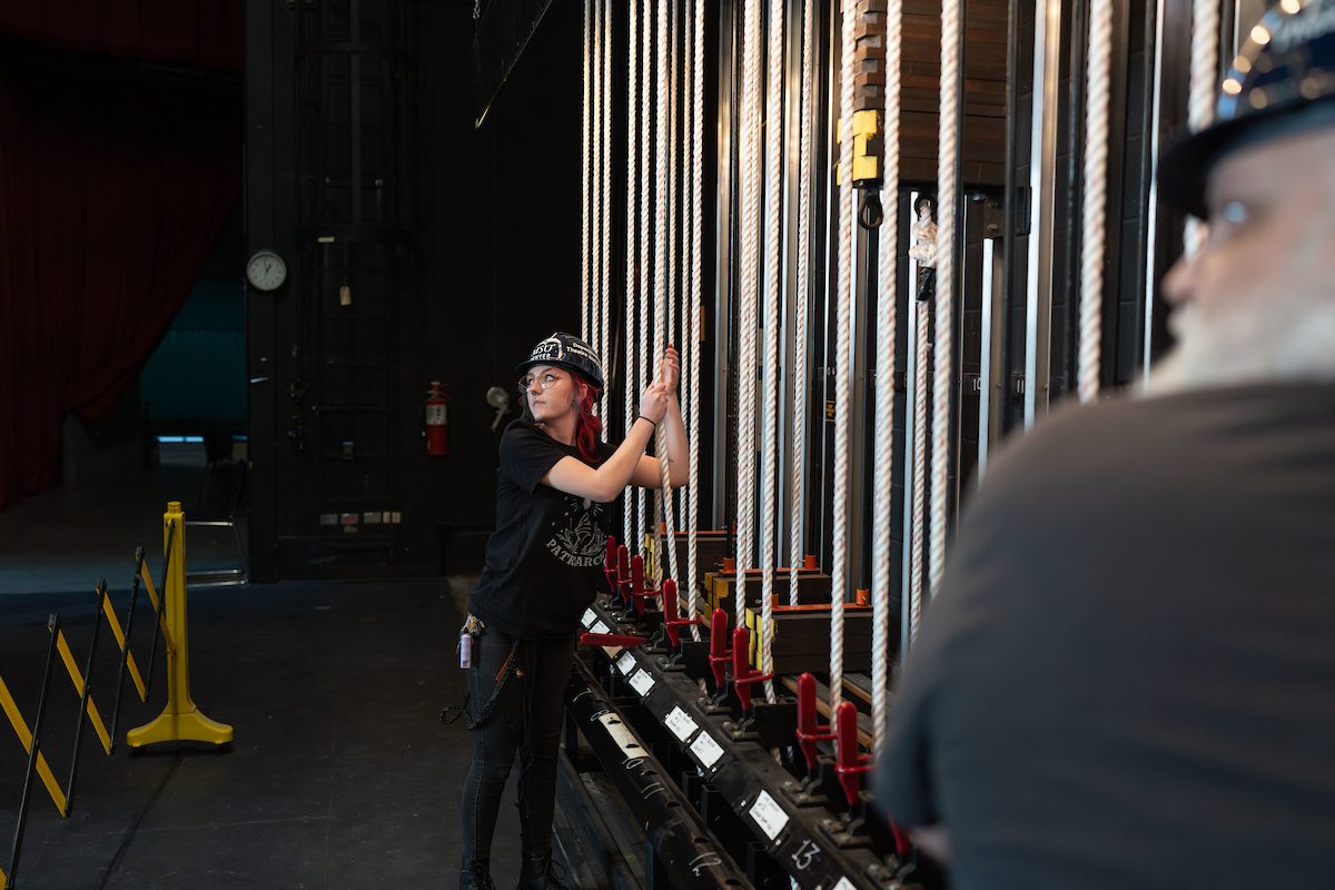 Zee Leona Howard and other work-study students hanging lights for an upcoming show, Footloose.