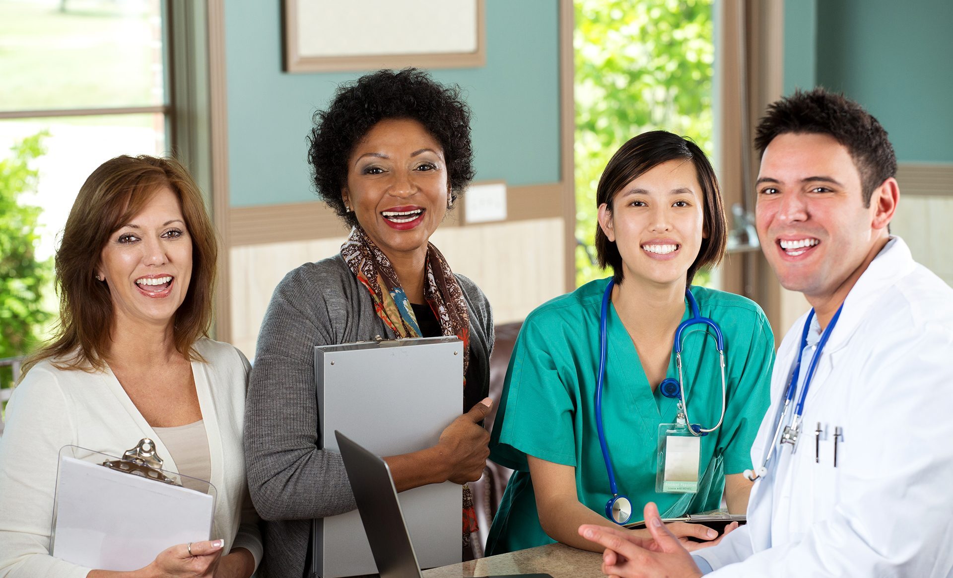 Community health workers with clipboards at desk with a doctor and a nurse