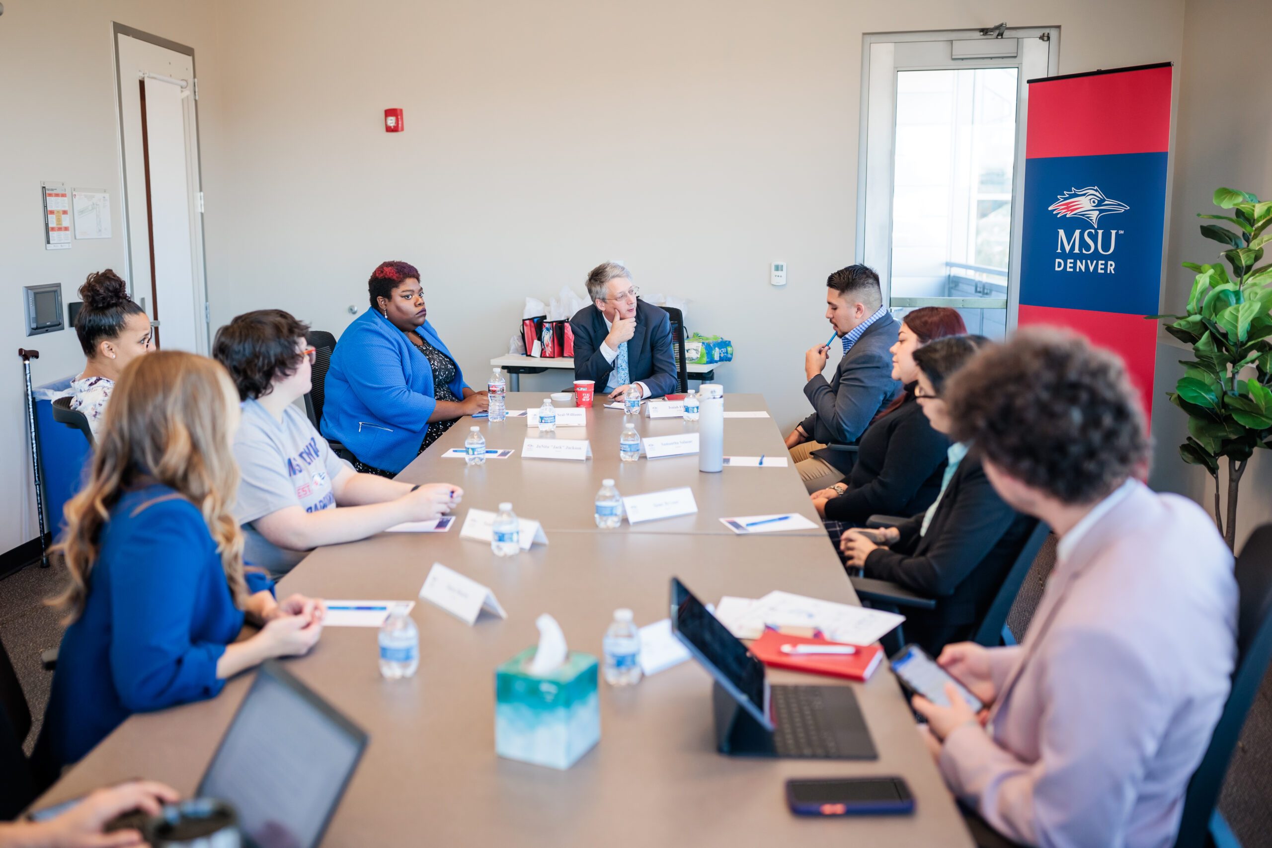 A group meets at a table in one of the CAVEA breakout rooms.