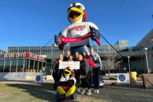 Students pose in front of a giant inflatable Rowdy mascot and with the regular Rowdy mascot.