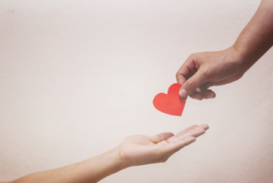 person hands another person a confetti heart