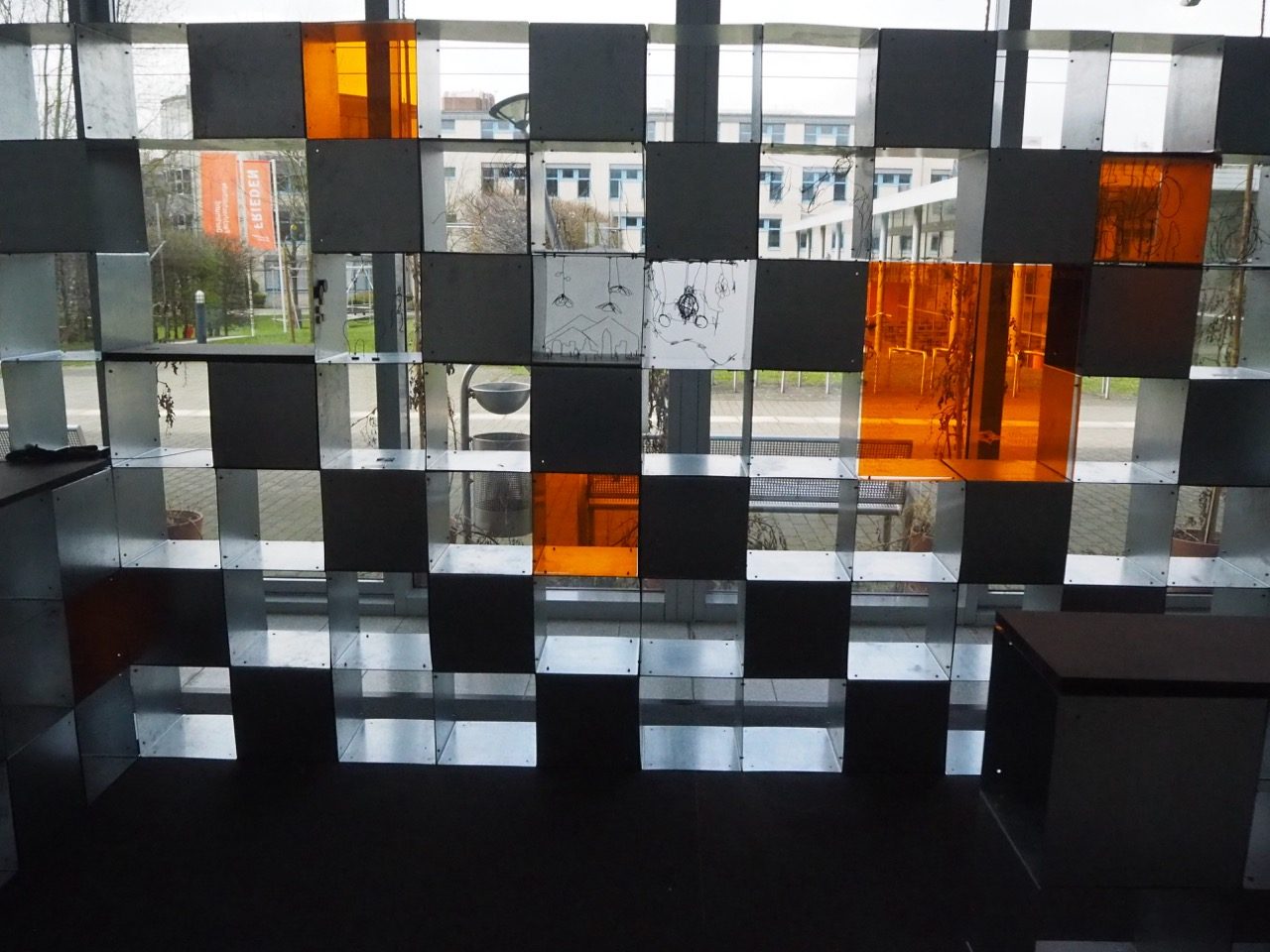 Looking outside through orange, clear, and black tiles