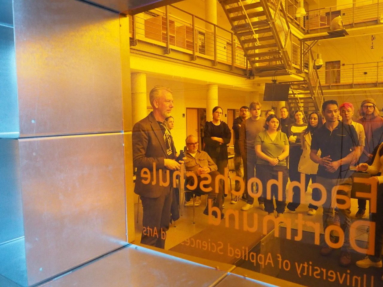 Looking through orange-stained plastic at students