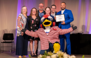 Rowdy the mascot poses with a group of people recognized at the Roadrunners Who Soar