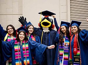 MSU Denver graduates pose for a photo with Rowdy at Spring 2024 Commencement.