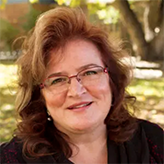 A picture of Dawn Materra Bassett with a leafy Auraria campus in the background