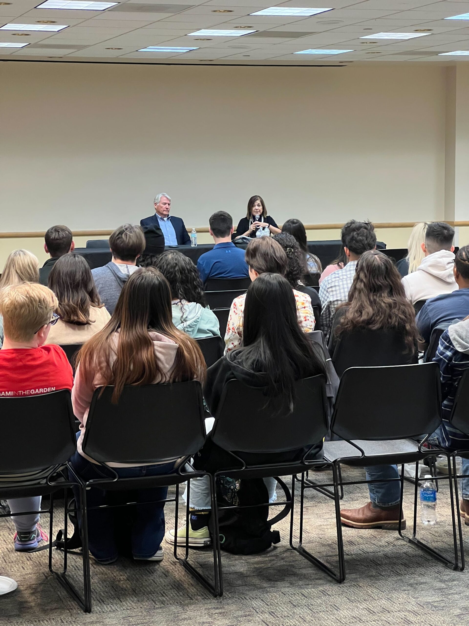 2 former congress members speaking to a room full of students