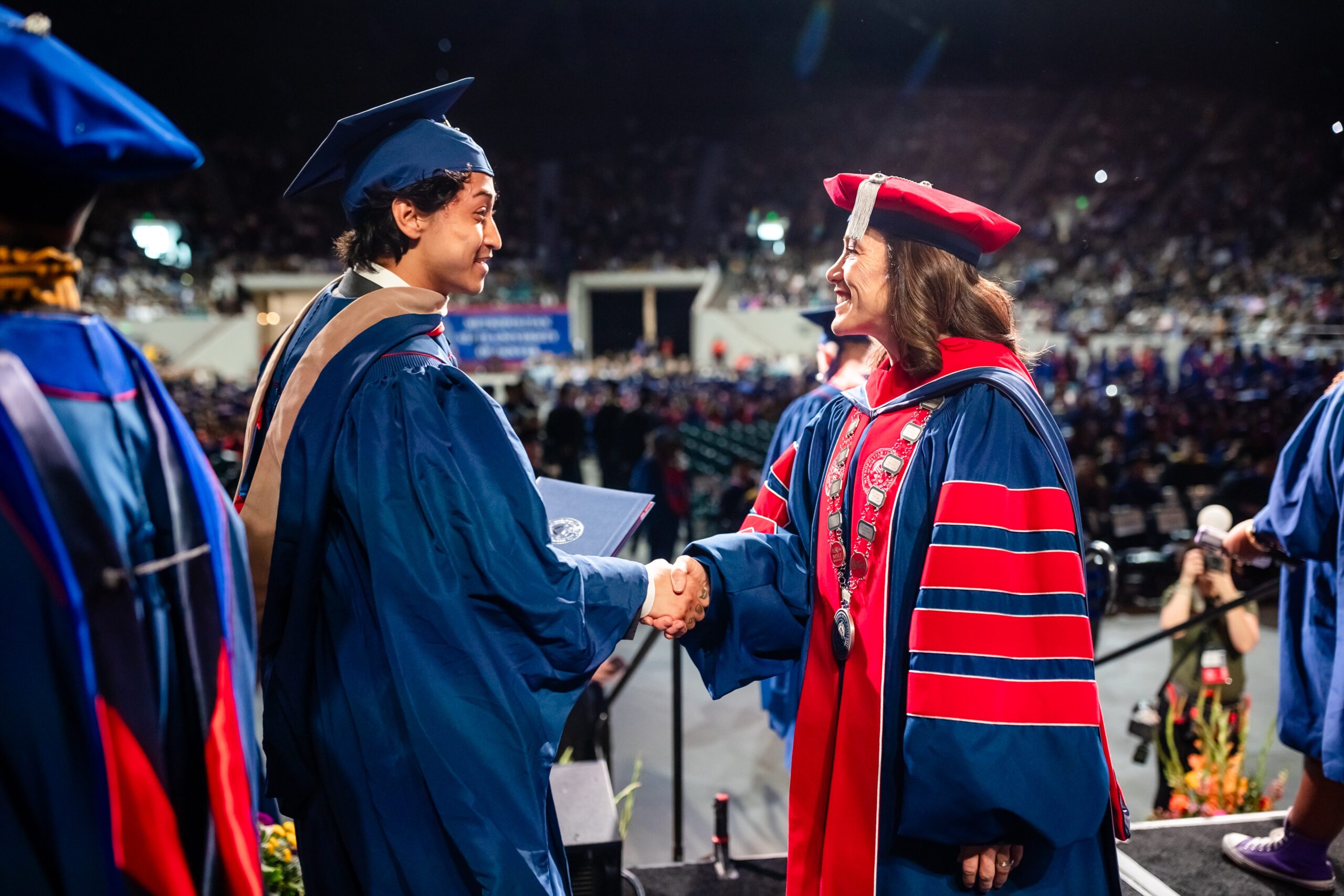 SP'24 graduate shaking Dr. Davidson's hand on commencement stage - MPAcc grad, Pujan Shrestha [MSU Denver photographer photo]