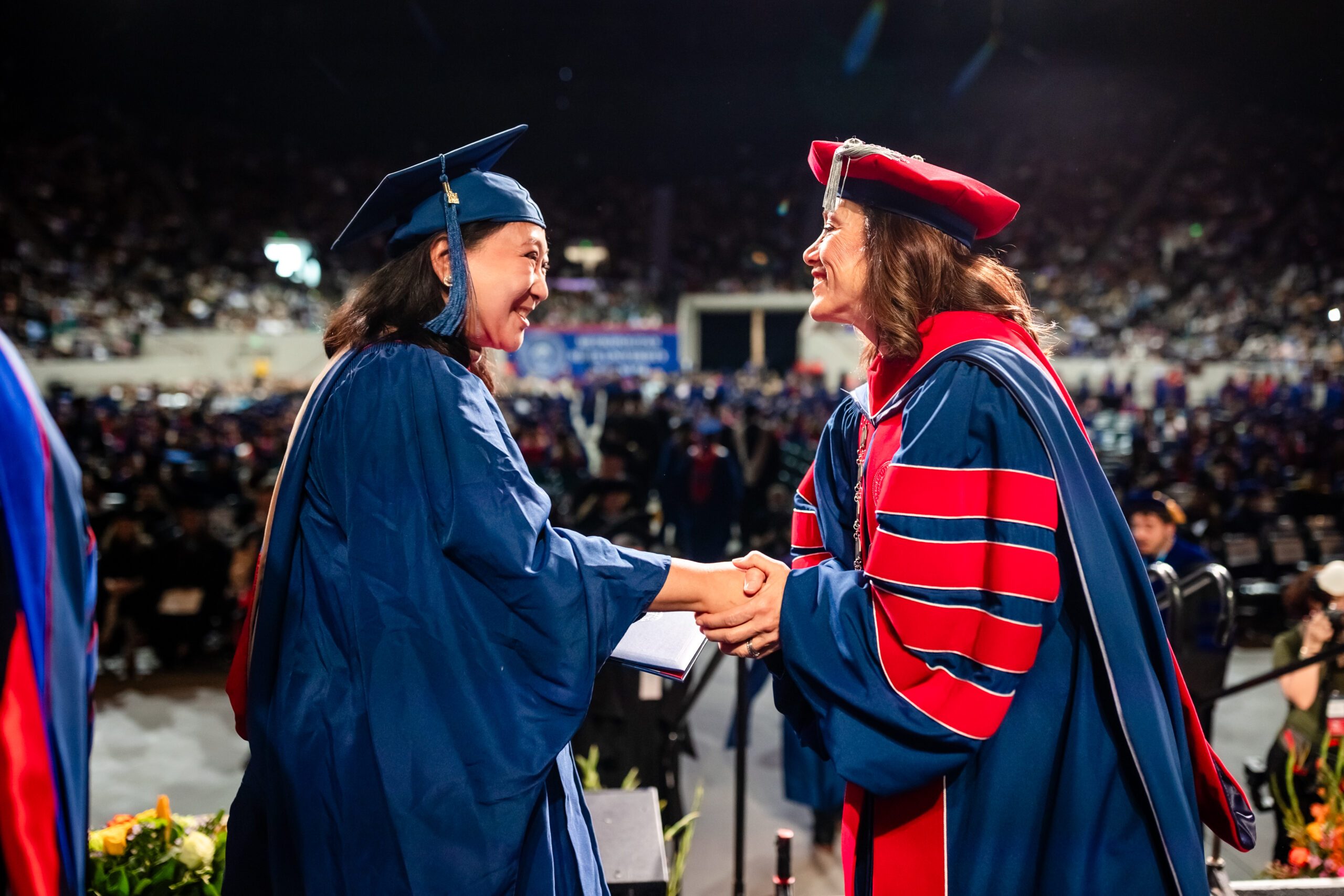 SP'24 graduate shaking Dr. Davidson's hand on commencement stage - Caroline Bellcourt (MPAcc) [MSU Denver photographer photo]