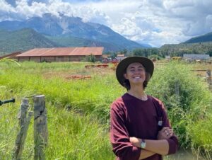 Ryan Sawyer in front of a green field and mountains.